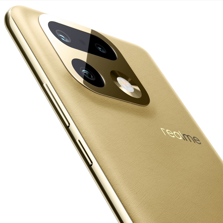 Un smartphone realme 16 Pro+ couleur or et ses écouteurs assortis posés sur une surface blanche réfléchissante, entourés d'un champ de blé doré sous un ciel clair.